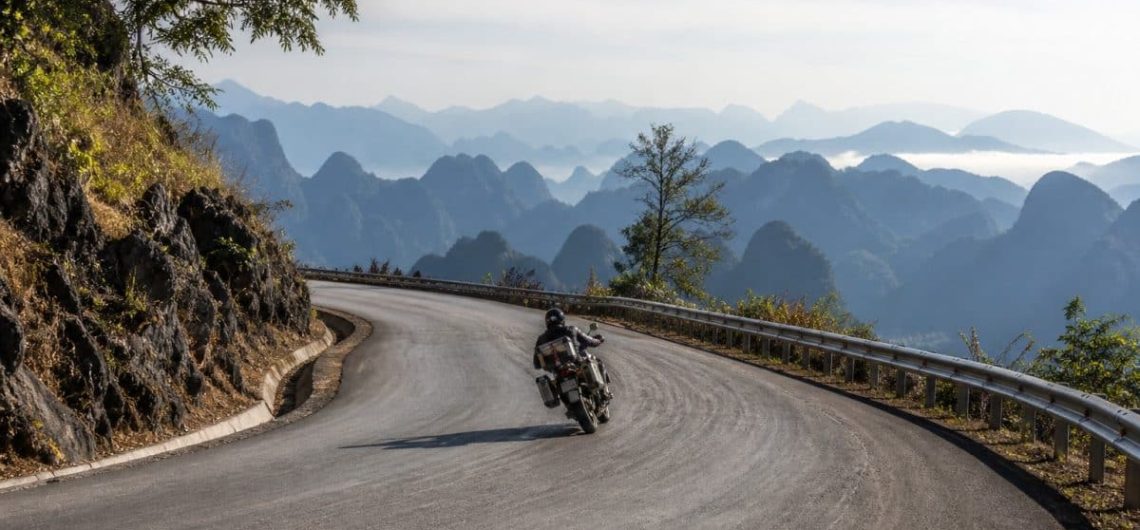 Mountain ridge road in northern Laos with limestone karst receding into haze